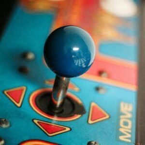 Close-up of a vibrant retro arcade joystick showcasing vintage gaming aesthetics with colorful design.